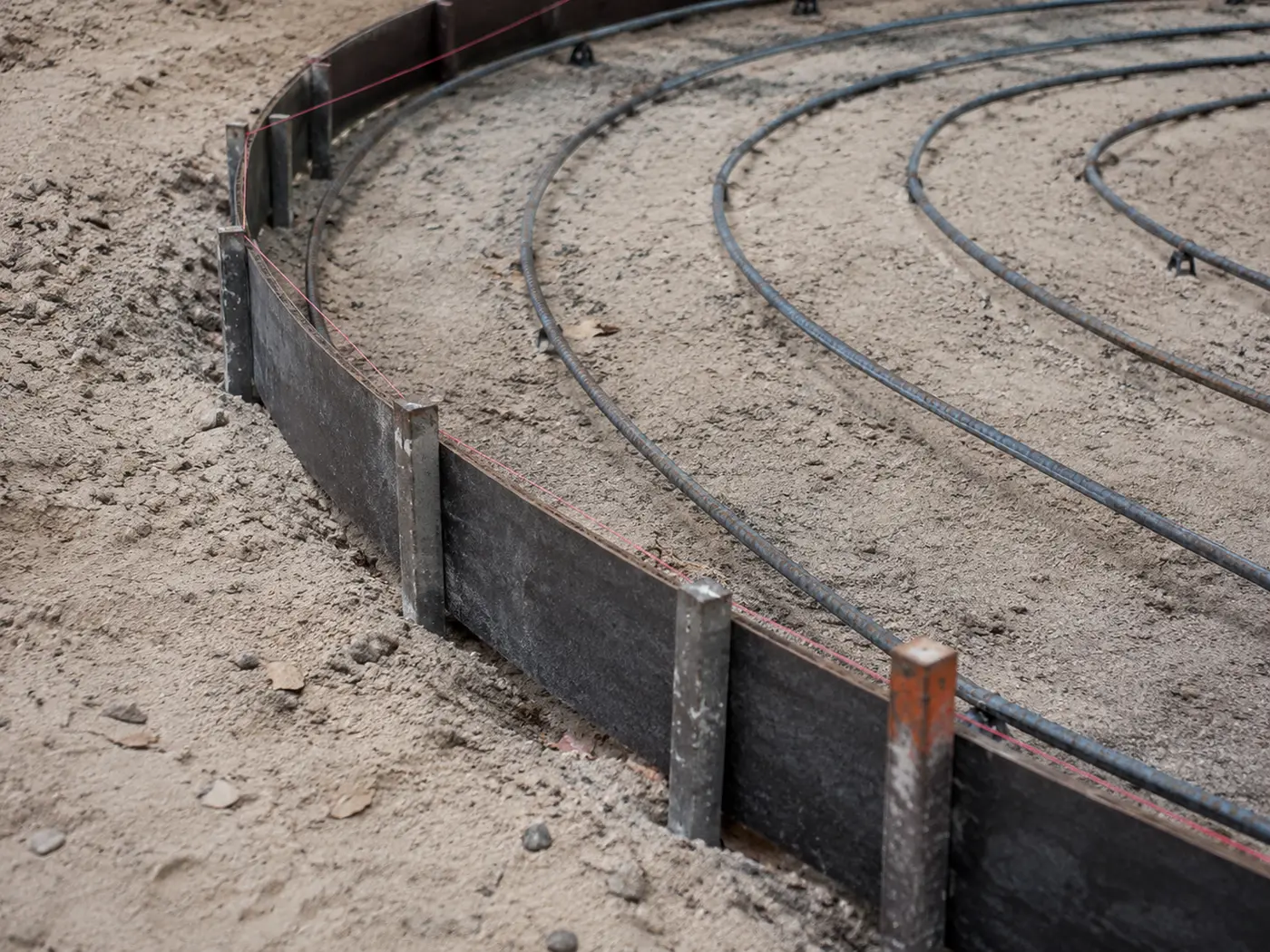 Flexible bender-board forms staked to a smooth radius with rebar bent to follow the arc