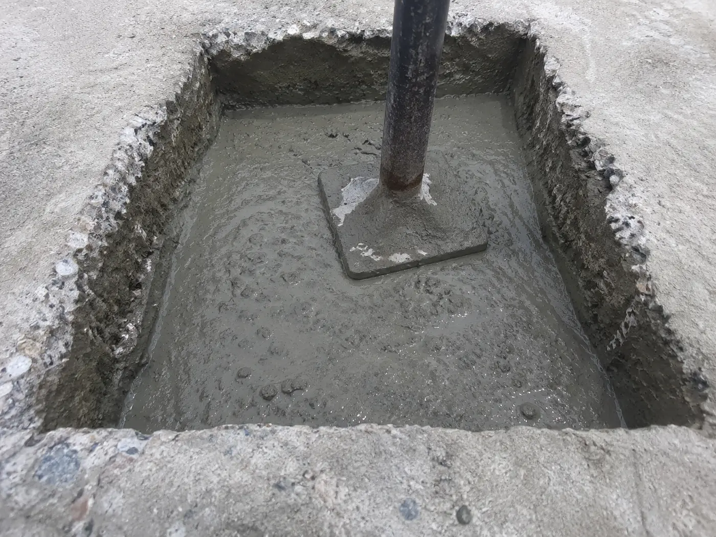 Rapid-set concrete and tamper in a squared-out pothole excavated to sound base