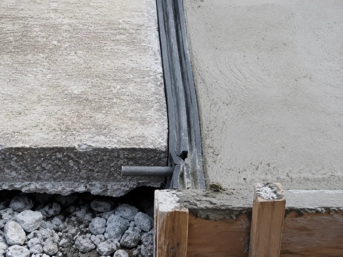 Expansion joint and dowel connection between an existing driveway edge and a formed widening strip