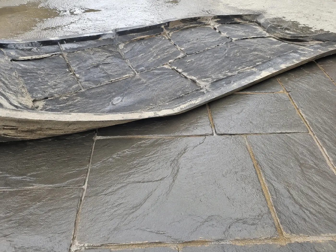 Polyurethane texture mat lifted from freshly stamped concrete with release powder in the joints