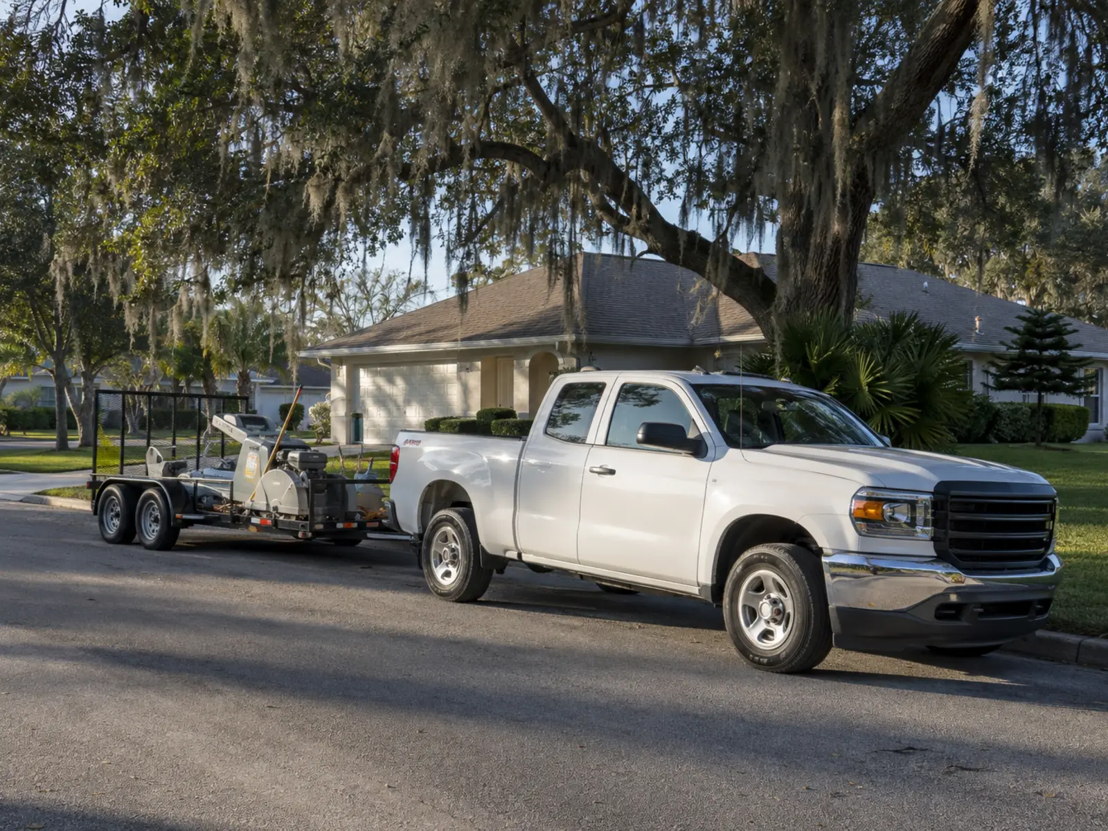 Contractor truck and equipment parked on a completed driveway approach